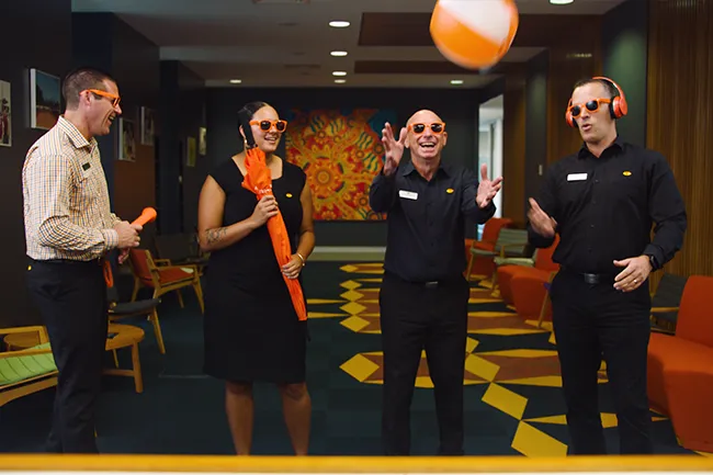 People playing with a beach ball inside Queensland Country Bank Head Office