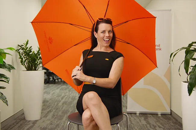 Person sitting on chair with orange umbrella in office setting