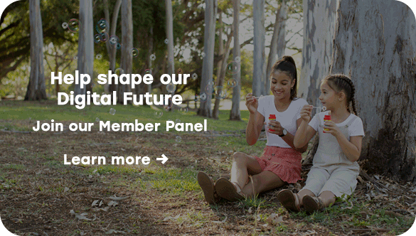 Two children sitting under trees in a park blowing bubbles, with overlaid text inviting users to join Queensland Country Bank&rsquo;s Member Panel and to &ldquo;Learn more&rdquo;.