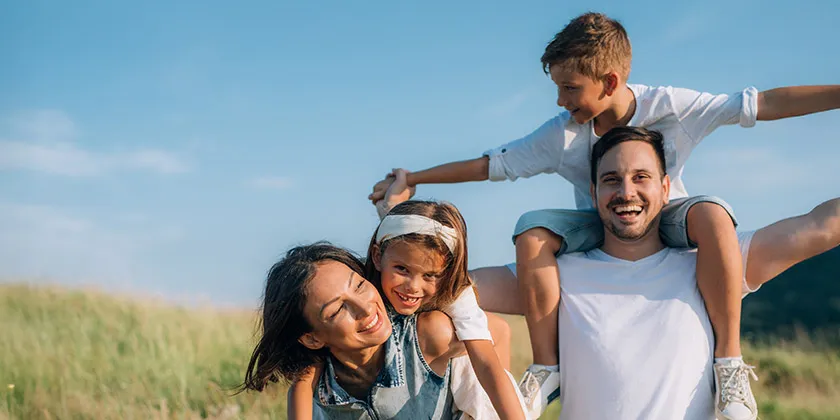A mother, Father, and two children in a field