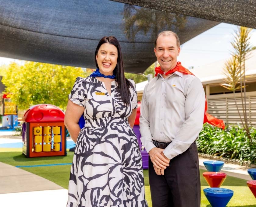 Queensland Country Bank CEO standing alongside RMHC North Australia CEO at Ronald McDonald House Townsville playground.