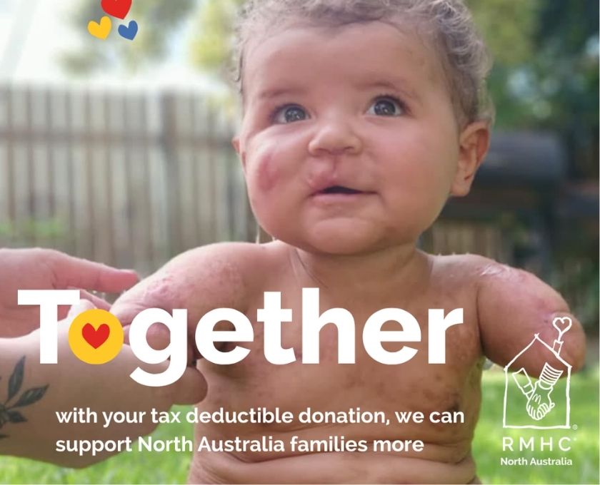 Outdoors scene with a blurred child with curly hair, set against greenery and a wooden fence. The Ronald McDonald House Charities logo appears on the left, showing two hands shaking inside a house outline with a heart-shaped chimney, accompanied by three heart icons in red, yellow, and blue.