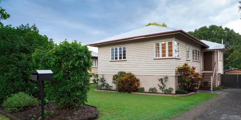 Queensland-style home with front lawn and garden, representing first home ownership.