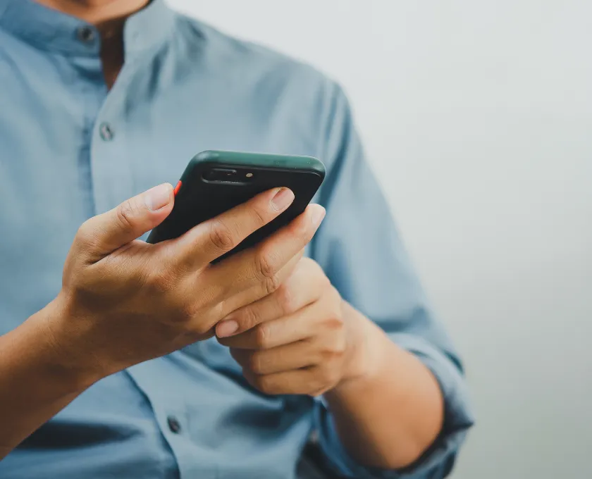Person checking messages on a smartphone, representing online communication risks