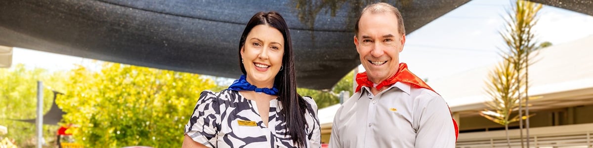 Queensland Country Bank CEO standing alongside RMHC North Australia CEO at Ronald McDonald House Townsville playground.