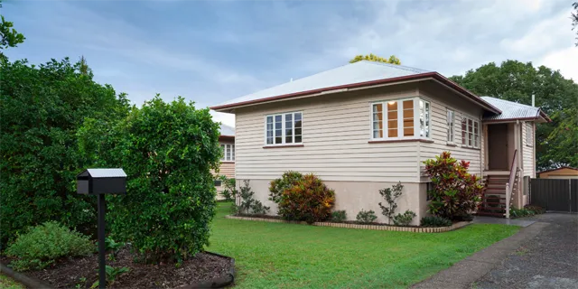 Queensland-style home with front lawn and garden, representing first home ownership.
