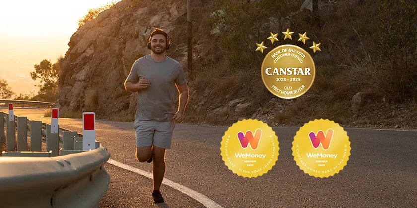 Person jogging along a winding road beside a rocky hillside at sunset, with safety barriers on the roadside and award badges displayed on the right.